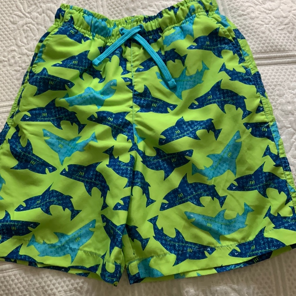 JK lime green with blue sharks swim trunks. Boys size 7